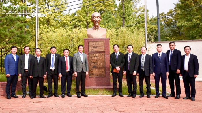 Các đại biểu chụp hình lưu niệm bên tượng chân dung Chủ tịch Hồ Chí Minh .