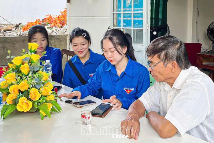 Đoàn viên, thanh niên phường Ninh Chử hướng dẫn người dân sử dụng các tiện ích số. Ảnh: LÂM ANH