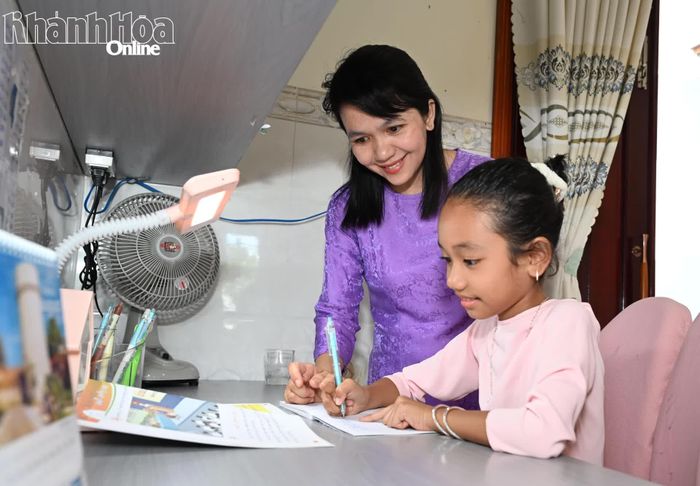 Bà Lưu Thị Thái Thanh kèm con luyện chữ Chăm tại nhà.