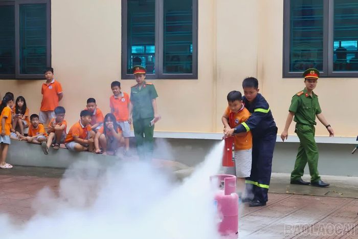 Học sinh được cán bộ, chiến sĩ Phòng Cảnh sát PCCC và CNCH hướng dẫn thực hành sử dụng bình chữa cháy xách tay.