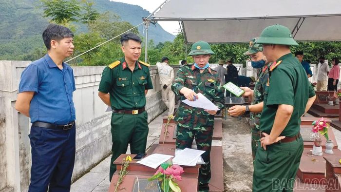 Lãnh đạo xã Cát Thịnh cùng lực lượng chức năng cẩn trọng đối soát thông tin trên từng phần mộ tổ chức khai quật.