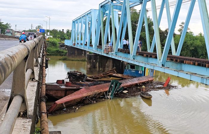 Chiếc sà lan đã bị lật nghiêng kẹp chiếc sà lan còn nổi vào phía trụ cầu.