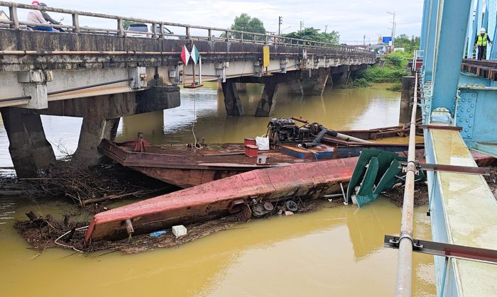 Phần mũi chiếc sà lan còn nổi kê vào trụ cầu.