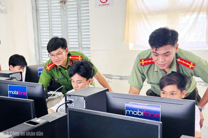 Thượng úy Lê Vũ Ca (bên trái) thường xuyên phối hợp tuyên truyền pháp luật về đảm bảo an ninh, an toàn thông tin tại các điểm trường trên địa bàn xã.
