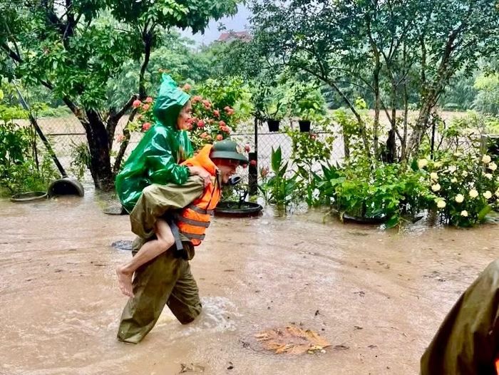 Công an xã Lao Bảo hỗ trợ người dân di dời khỏi khu vực ngập lụt, đồng thời vận chuyển tài sản đến nơi an toàn.