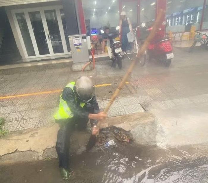Công nhân thoát nước theo dõi dòng chảy, kịp thời vớt rác, lá cây tại các cửa thu nước ở khu vực phường Ngũ Hành Sơn.