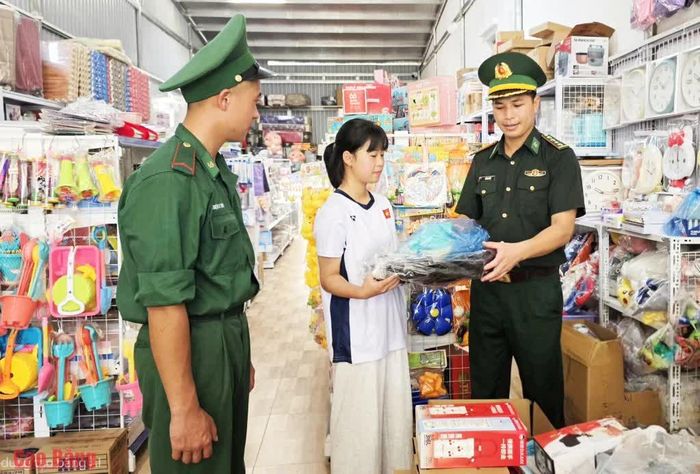 Cán bộ Đồn Biên phòng Cửa khẩu quốc tế Trà Lĩnh mua đồ dùng học tập cho em Lục Hồ Điệp.