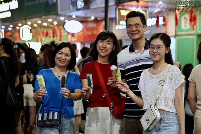 Chị Việt Hồng (áo đỏ) cùng người thân check-in trước số 35 Tràng Tiền. Ảnh: Linh Vũ, Hà Thương