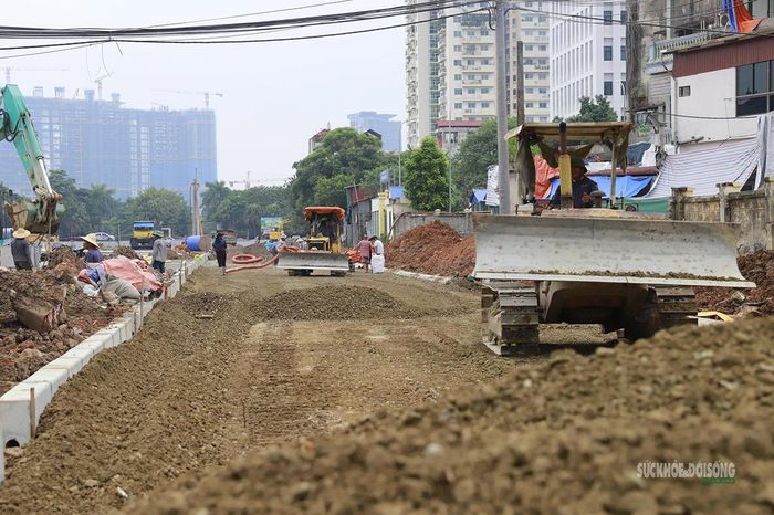 Máy xúc thi công đồng thời nền đường và hệ thống hạ tầng kỹ thuật. Ảnh: T.Anh