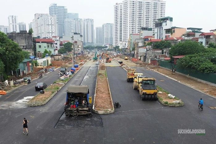 Mặt đường mới thảm nhựa dần rõ hình hài tuyến giao thông đô thị. Ảnh: T.Anh