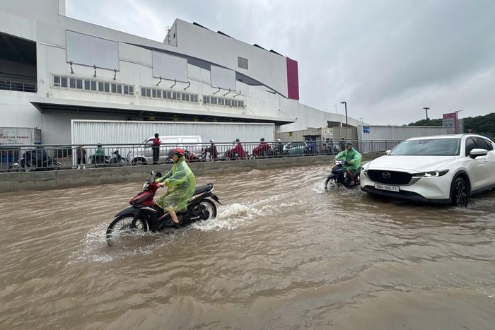 Mực nước ngập cao nửa bánh xe khiến nhiều phương tiện di chuyển khó khăn, một số người quyết định tắt máy dắt bộ để phòng chết máy. 