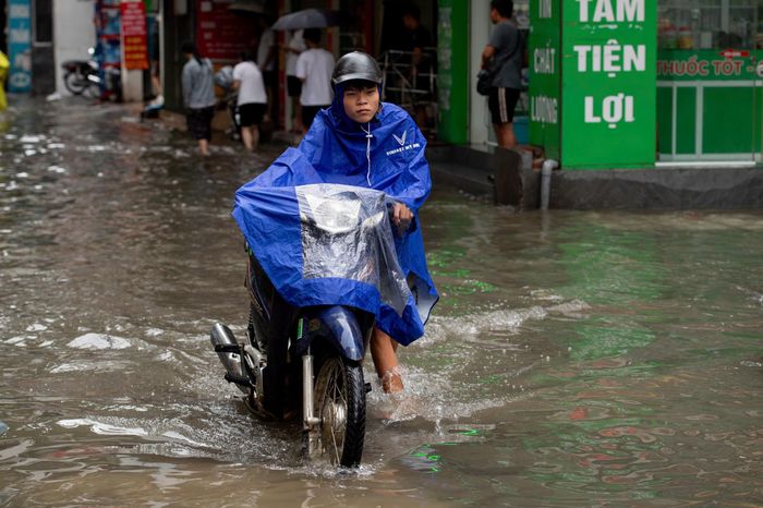 Một số người chọn dắt bộ qua điểm ngập để tránh nguy cơ xe chết máy. Đường Triều Khúc cũng là một trong những điểm ngập úng thường xuyên tại Hà Nội mỗi khi có mưa lớn kéo dài.