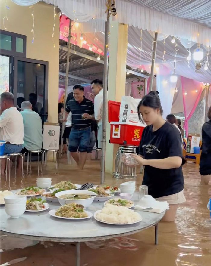 Quan khách vui vẻ xắn quần, đứng ăn cỗ ở nhà cô dâu chiều 13/9. Ảnh cắt từ clip.