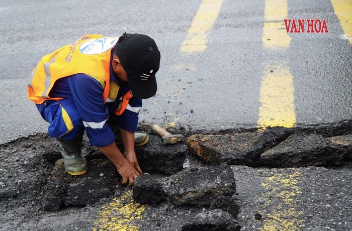 Công nhân tiến hành khắc phục tạm thời các vị trí hư hỏng trên Quốc lộ 1 qua xã Hưng Lộc. Ảnh: S.Thùy
