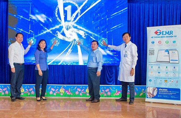 Các đại biểu thực hiện nghi thức đưa bệnh án điện tử vào sử dụng tại Trạm Y tế Mỹ Đức