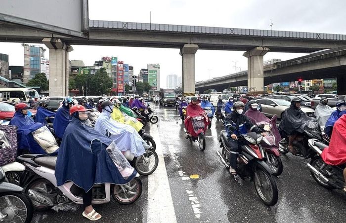 Người dân vất vả di chuyển trong điều kiện thời tiết không thuận lợi và giao thông ùn tắc tại ngã tư Nguyễn Xiển - Nguyễn Trãi. Ảnh: Quốc Lũy - TTXVN