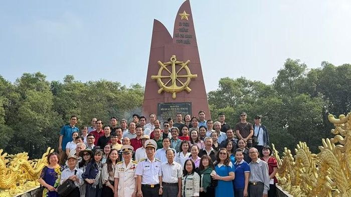 Các đại biểu, nhân vật lịch sử, cùng văn nghệ sĩ thành phố chụp ảnh lưu niệm tại Khu tưởng niệm Đoàn tàu không số Bến Lộc An. (Ảnh: HOÀI SƠN)