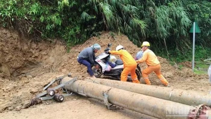 Nhân viên Điện lực Nghĩa Lộ hỗ trợ người dân đưa phương tiện qua khu vực sạt lở, góp phần bảo đảm an toàn giao thông trong vùng bị chia cắt.