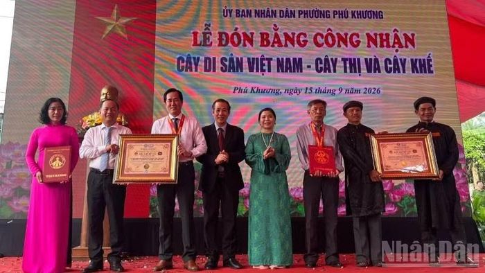 Trao bằng kỷ lục Việt Nam đối với cây Bạch Mai cho lãnh đạo chính quyền địa phương và đại diện Đình Phú Tự. (Ảnh: HOÀNG TRUNG)