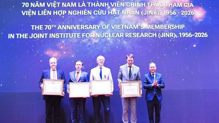 Giáo sư, Tiến sĩ Trần Hồng Thái, Ủy viên Trung ương Đảng, Chủ tịch Viện Hàn lâm Khoa học và Công nghệ Việt Nam trao tặng kỷ niệm chương vinh danh các nhà lãnh đạo, các nhà khoa học xuất sắc của JINR. (Ảnh: XUÂN KỲ)