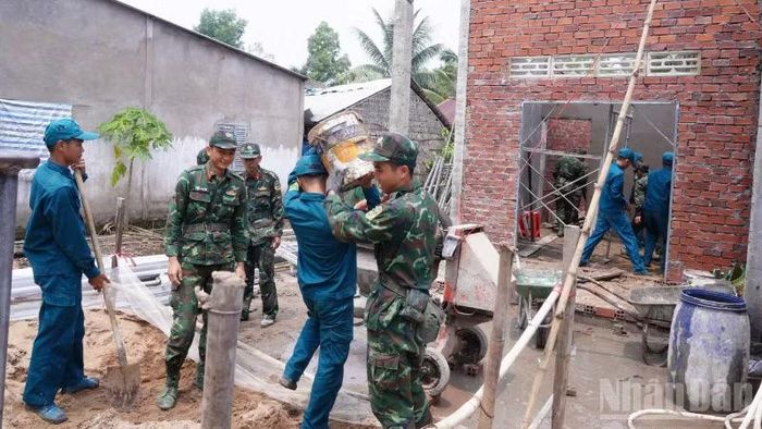 Cán bộ, chiến sĩ tích cực phối hợp các lực lượng tại chỗ triển khai xây mới, sửa chữa 125 căn nhà đúng tiến độ, bảo đảm chất lượng. (Ảnh: CÔNG KHANH)