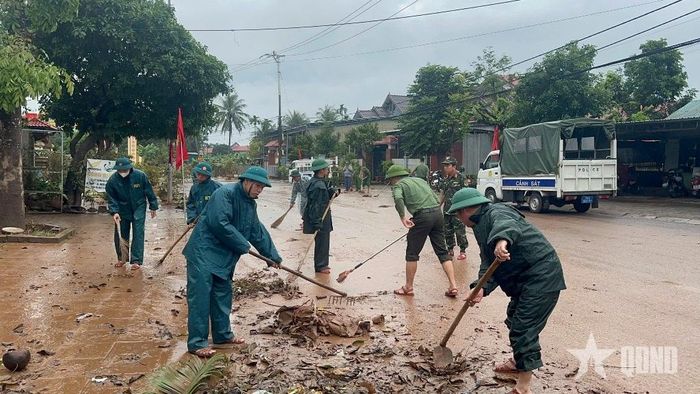 Bộ đội, dân quân và các lực lượng khẩn trương vệ sinh môi trường sau lũ.  