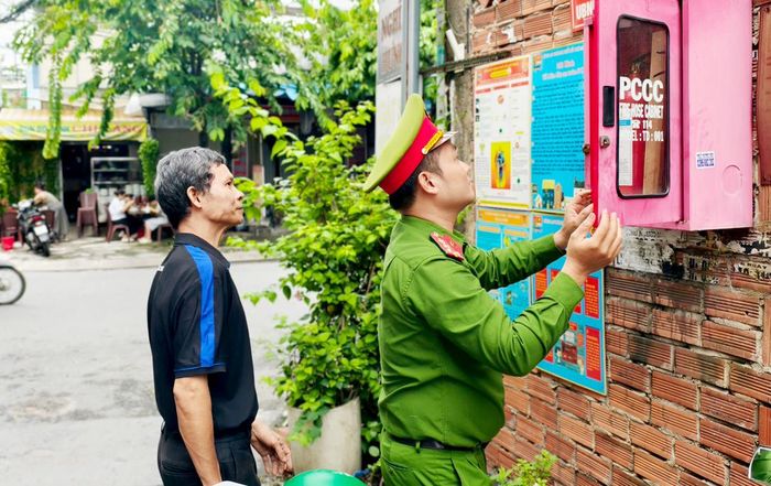 Ông Trần Văn Ro, Tổ trưởng Tổ liên gia an toàn PCCC cùng Công an phường Đông Hưng Thuận, TPHCM kiểm tra thiết bị PCCC. Ảnh: NGUYỄN TÂN
