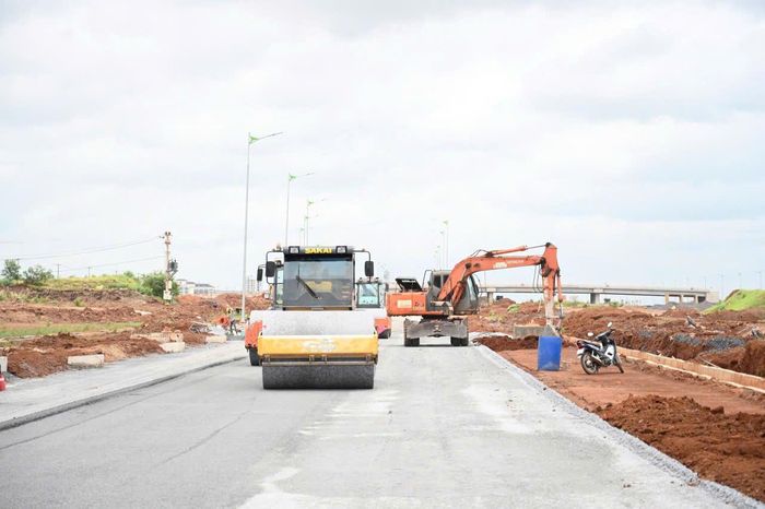 Các đơn vị tranh thủ thi công mặt đường trục chính khi nắng ráo. Ảnh: LÊ XUÂN
