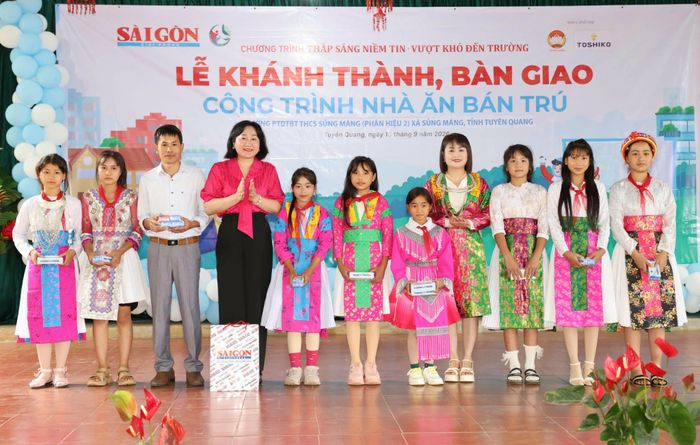  Bà Bùi Thị Hồng Sương tặng bút cho các em học sinh. Ảnh: QUANG PHÚC 