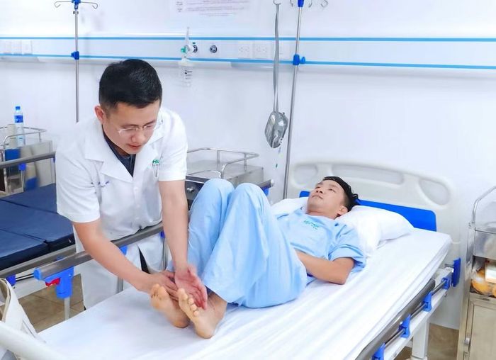 Bác sĩ kiểm tra chân bệnh nhân sau phẫu thuật - Ảnh BVCC