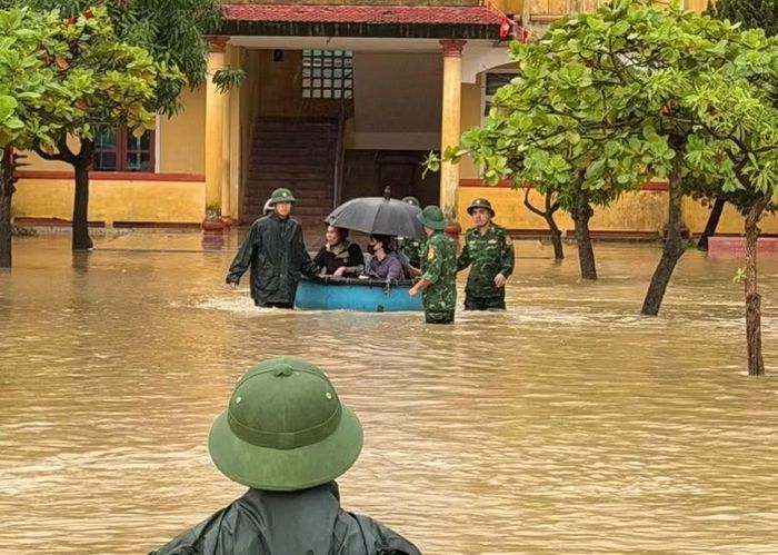 Cán bộ, chiến sĩ Ban Chỉ huy Biên phòng Cửa khẩu cảng Vũng Áng - Sơn Dương dùng thuyền thúng hỗ trợ đưa giáo viên và học sinh ra ngoài.