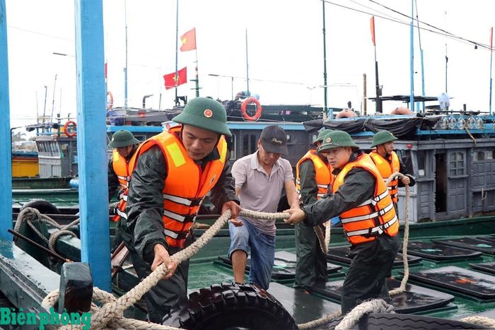 Cán bộ, chiến sĩ Đồn Biên phòng cửa khẩu cảng Thuận An, Bộ đội Biên phòng thành phố Huế phối hợp hỗ trợ trục vớt tàu cá của ngư dân bị sự cố do dông gió, sóng lớn. Ảnh: Mai Trang