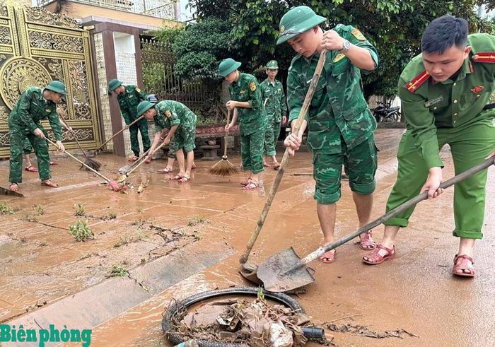 Cán bộ, chiến sĩ Đồn Biên phòng cửa khẩu quốc tế Lao Bảo, Bộ đội Biên phòng tỉnh Quảng Trị phối hợp với chính quyền địa phương giúp người dân dọn dẹp sau mưa lũ. Ảnh: Đình Tiến