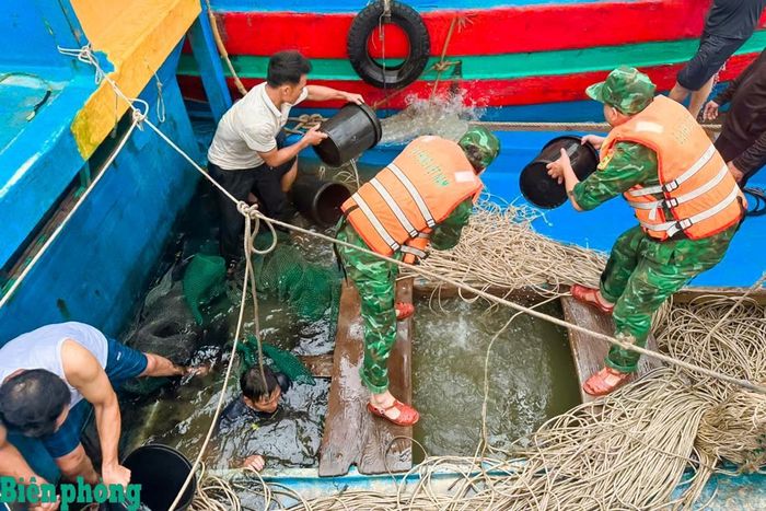 Cán bộ, chiến sĩ Đồn Biên phòng Hải Hòa, Bộ đội Biên phòng tỉnh Thanh Hóa cùng người dân tát nước, khắc phục sự cố tàu cá TH-91594-TS bị chìm tại khu neo đậu Lạch Ghép, sáng 13/9/2026. Ảnh: Hải Chuyền