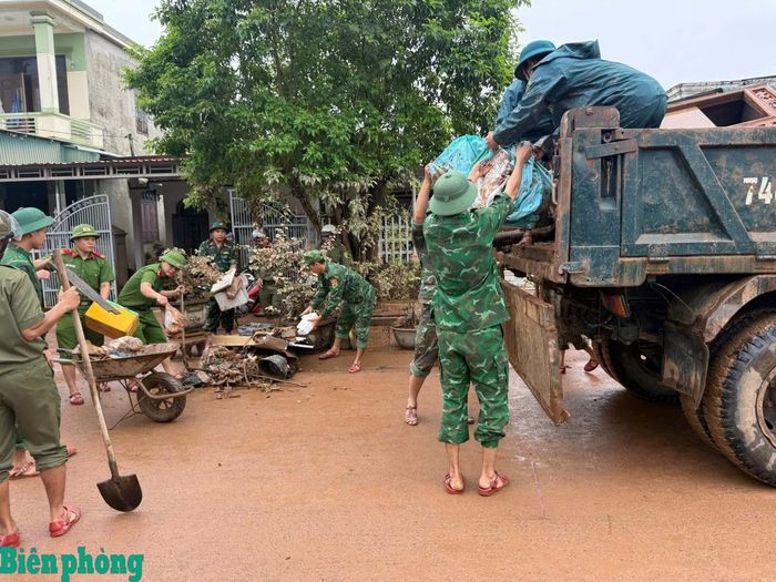 Cán bộ, chiến sĩ Bộ đội Biên phòng tỉnh Quảng Trị phối hợp với các lực lượng và nhân dân thu gom, vận chuyển rác thải, bùn đất sau mưa lớn, góp phần vệ sinh môi trường, ổn định đời sống người dân. Ảnh: Đình Tiến