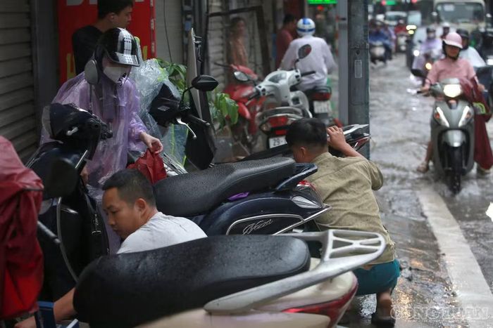 Các cửa hàng sửa chữa xe máy cũng nhanh chóng có mặt bên khu vực ngập để hỗ trợ người dân khắc phục sự cố.