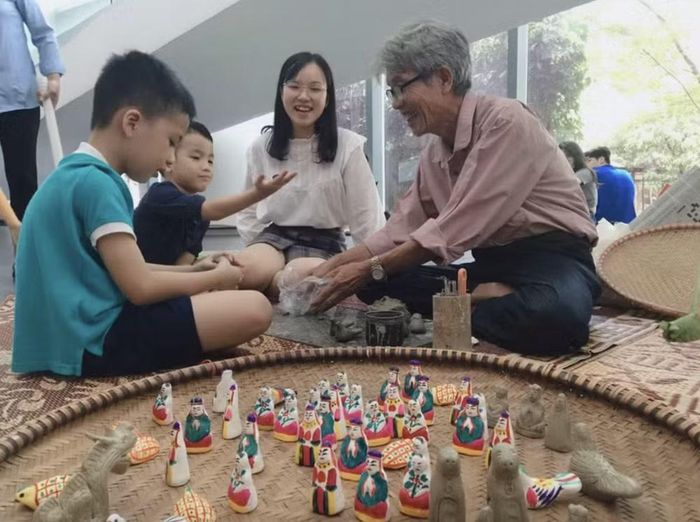 Nghệ nhân hướng dẫn các em nhỏ làm con giống đất nặn. Ảnh: Bảo tàng Dân tộc học Việt Nam