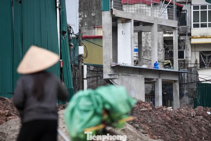 Căn nhà ba tầng nằm trên thửa đất hình tam giác mới được chủ nhà sửa chữa, xây lại phần khung bê tông theo diện tích đất còn lại sau giải phóng mặt bằng.