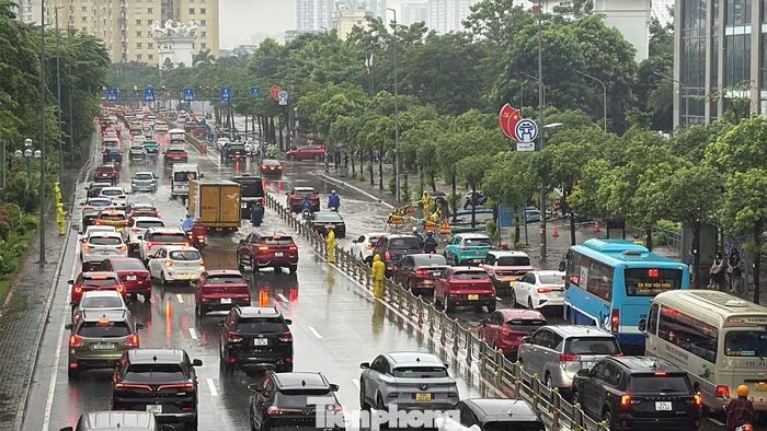 Phương tiện trên đường Võ Chí Công tăng nhanh vào giờ cao điểm, khiến việc lưu thông qua khu vực ngập thêm khó khăn.
