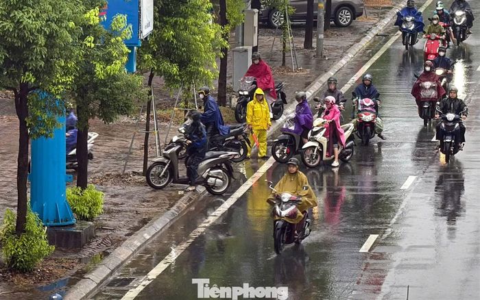 Nước ngập khiến một số người đi xe máy di chuyển lên vỉa hè để tránh đoạn ngập.
