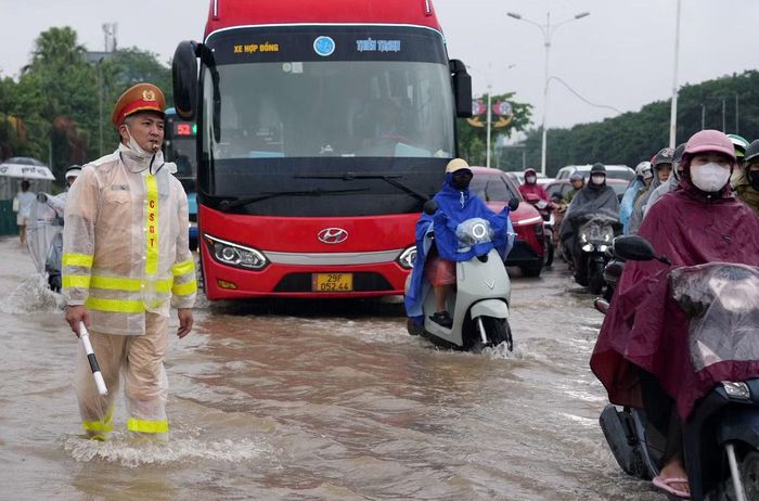 Lực lượng CSGT phân luồng giao thông qua khu vực ngập nước.