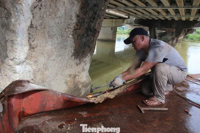 Sà lan lớn dài khoảng 30 m, rộng gần 5 m, đầu mắc vào trụ cầu đường bộ, đuôi mắc vào trụ cầu đường sắt, cabin vướng vào lan can cầu. Hai sà lan nhỏ nằm chồng lên nhau, một chiếc mắc phía trên khu vực dầm cầu, chiếc còn lại lật nghiêng. Dòng nước lũ cuốn theo cây cối, rác và nhiều vật trôi, quấn chặt phía dưới các phương tiện, khiến việc giải cứu gặp nhiều khó khăn.