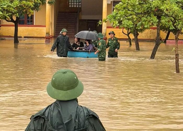 Bộ đội dùng thuyền thúng hỗ trợ đưa giáo viên, học sinh ra khỏi khu vực ngập nước.