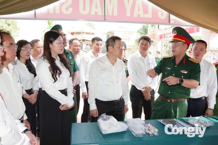 Lãnh đạo thành phố kiểm tra quy trình lấy mẫu sinh phẩm phục vụ giám định ADN tại một nghĩa trang liệt sĩ ở Đà Nẵng.