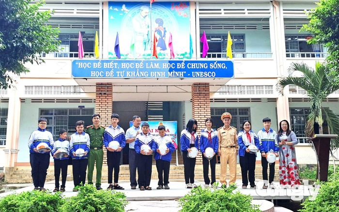 Học sinh được tặng mũ bảo hiểm tại một buổi tuyên truyền.