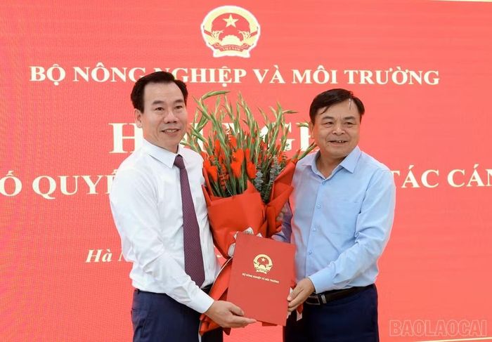 Thứ trưởng Bộ Nông nghiệp và Môi trường Nguyễn Hoàng Hiệp trao quyết định và tặng hoa chúc mừng ông Dương Đức Huy. Ảnh: Báo Lào Cai