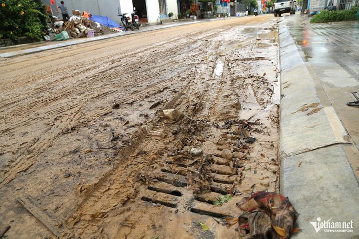 Miệng cống thoát nước bị đất và lá cây vùi lấp, khiến dòng chảy bị cản trở. Ảnh: Phạm Công