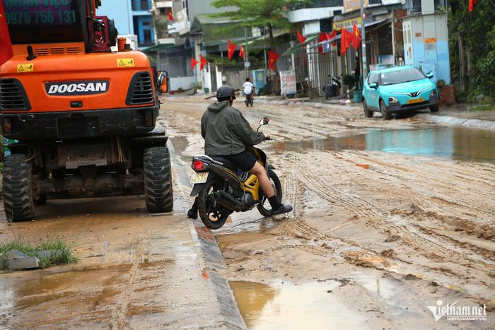 Người dân chọn những nơi bùn mỏng để di chuyển tránh bị ngã. Ảnh: Phạm Công