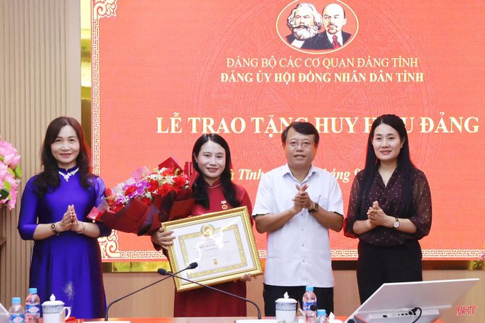 Các đồng chí Dương Tất Thắng - Ủy viên BTV Tỉnh ủy, Bí thư Đảng ủy, Phó Chủ tịch Thường trực HĐND tỉnh; Nguyễn Thị Việt Hà - Tỉnh ủy viên, Phó Bí thư Đảng ủy, Phó Chủ tịch HĐND tỉnh; Nguyễn Thị Mai Thủy - Tỉnh ủy viên, Phó Bí thư Đảng ủy các cơ quan Đảng tỉnh trao Huy hiệu 30 năm tuổi Đảng và tặng hoa chúc mừng đồng chí Nguyễn Thị Nhuần.
