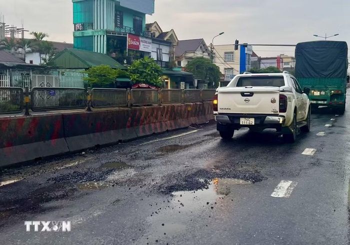 Đoạn đường Quốc lộ 1A đi qua phường Quảng Trị xuất hiện nhiều điểm hư hỏng, mặt đường bị lún, gây mất an toàn giao thông. (Ảnh: Nguyên Linh/TTXVN)